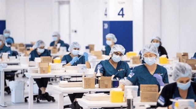 Staff members prepare vaccines at a New South Wales coronavirus disease (COVID-19) mass vaccination hub as it opens at Sydney Olympic Park in Sydney, Australia, May 10, 2021. (James Gourley/Pool via Reuters)
