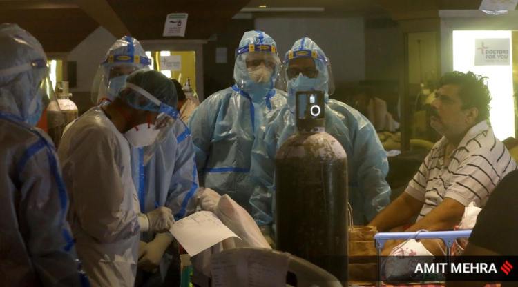 Health workers check patients receiving treatment inside a banquet hall converted into a Covid-19 isolation center in New Delhi on Saturday, May 8, 2021. (Express photo by Amit Mehra)