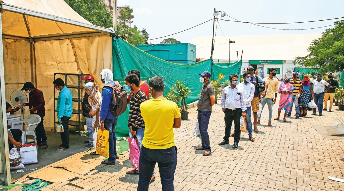 Relatives of patients admitted in a ‘jumbo’ Covid facility in Pune line up to deliver essentials on Saturday. (Photo: Ashish Kale)