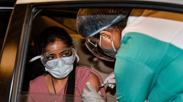 A health worker administers a dose of the COVID-19 vaccine to a woman, at a drive-through vaccination camp at Select City Walk mall, in New Delhi, Thursday, May 27, 2021. (PTI Photo)