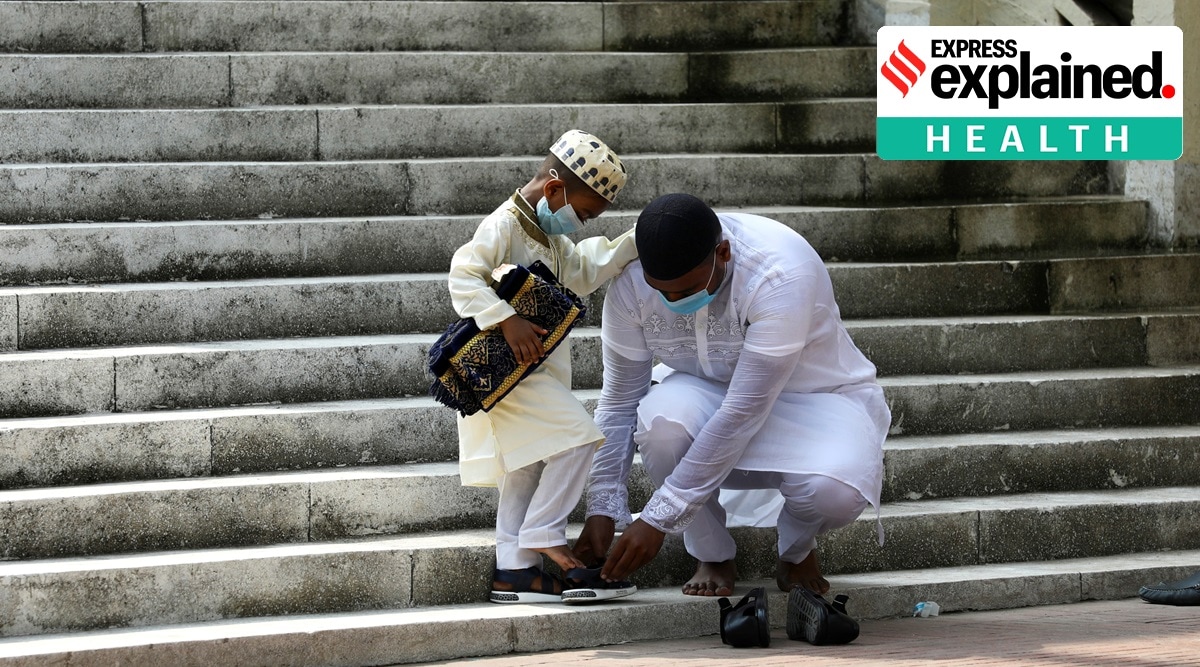 A man helps a child put on his shoes as they leave a mosque in Dhaka, Bangladesh. Mask advocacy by Imams during Friday prayers is one of the strategies used to promote mask usage. (Reuters Photo: Mohammad Ponir Hossain)
