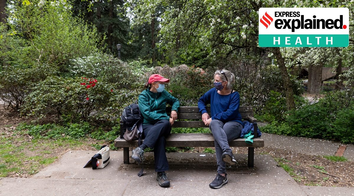 Kate Fassett, left, and Rachel O’Doud-Vega, masked and chatting at Mt. Tabor Park in Portland, Ore., on April 29, 2021. (Kristina Barker/The New York Times)