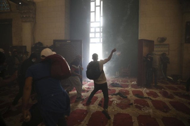 Palestinians inside the Al-Aqsa mosque clash with Israeli security forces at the Al Aqsa Mosque compound in Jerusalem's Old City Monday, May 10, 2021. (AP Photo)