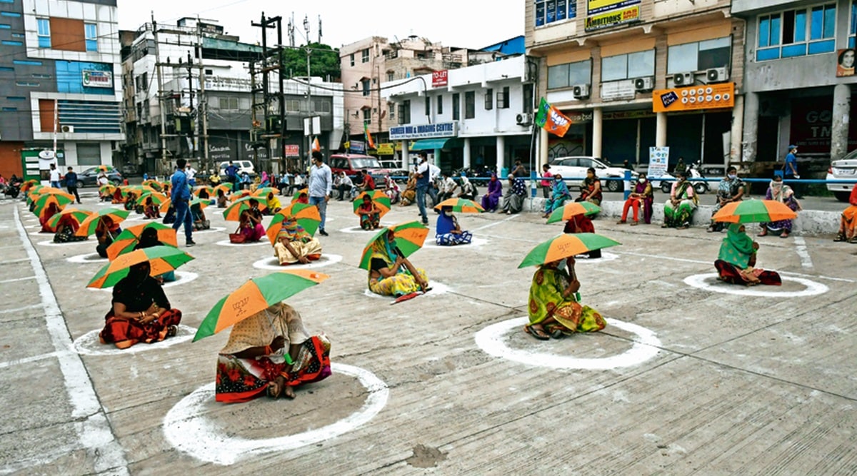Slum dwellers queue up for ration at an event organised by the BJP to commemorate the completion of seven years of the Modi government, in Bhopal on Sunday. (Photo: PTI)