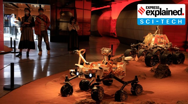 Visitors pass by an exhibition depicting rovers on Mars in Beijing on Friday, May 14, 2021. (AP Photo/Ng Han Guan)