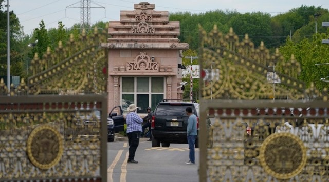 People stand near the entrance to the BAPS Shri Swaminarayan Mandir in Robbinsville Township, N.J., Tuesday, May 11, 2021. (AP Photo/Seth Wenig)