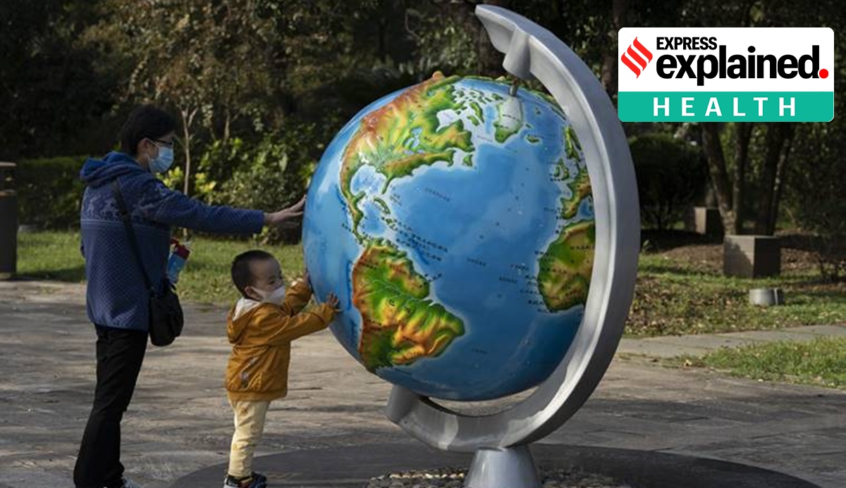 A child and woman, wearing masks to protect from the coronavirus, look at a giant globe in Wuhan on Thursday, Oct. 22, 2020. (AP Photo/Ng Han Guan)