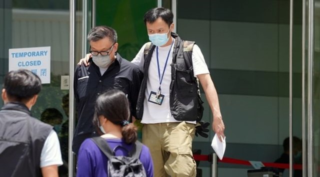 Police officers from the national security department escort Apple Daily Digital Platform Director Cheung Chi-wai from the offices of Apple Daily and Next Media in Hong Kong, China June 17, 2021. (Photo: REUTERS/Lam Yik)