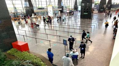 Passengers wait next to a giant suitcase outside the terminal building of  Bengaluru International Airport at its opening in Devanahalli, on the  outskirts of Bangalore, India, Friday, May 23, 2008. The Bengaluru