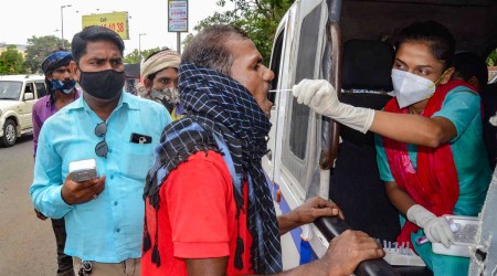 A medic collects swab sample from a man for Covid-19 testing in Bhopal. (Photo: PTI)