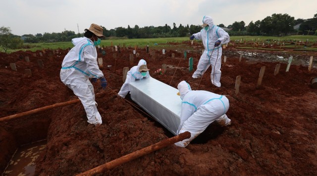 Workers bury a Covid-19 victim at the Padurenan cemetery in Bekasi, West Java, Indonesia, on Thursday. (Photo: AP)