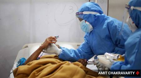 Health workers speak to a Covid-19 patients at a hospital in New Delhi (Express photo: Amit Mehra, File)