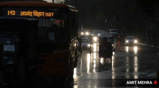 Vehicles wade through a waterlogged street after heavy rains in New Delhi on June 4. (Express Photo: Amit Mehra, File)
