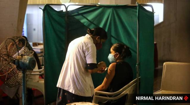 Health workers administering Covid-19 vaccine at Tagore Hall, Ahmedabad. 
(Express photo by Nirmal Harindran)