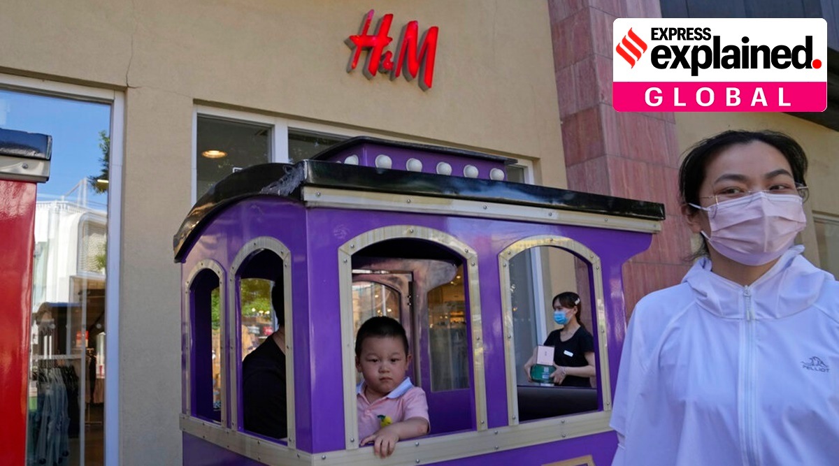 A child in a toy train passes a H&M store in Beijing. (AP Photo)
