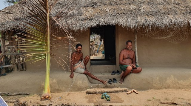 A father and son sit outside their home in Odisha's Barahipur, Satabhaya. (Express Photo:  Aishwarya Mohanty)