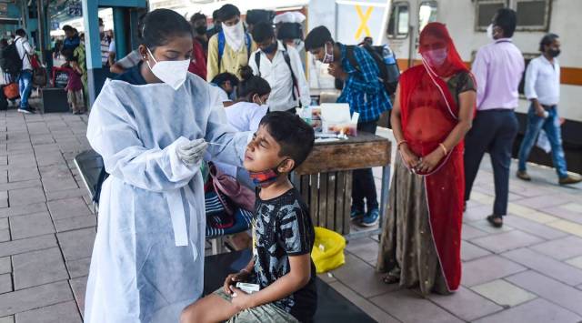 A BMC health worker takes swab sample of a child passenger for COVID-19 test, at Dadar railway station in Mumbai. (PTI)