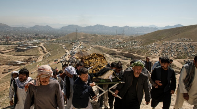 People perform a funeral ceremony on May 9, 2021, for a girl killed in powerful explosions outside a high school in a predominantly Hazara neighborhood in Kabul, Afghanistan. (The New York Times)

