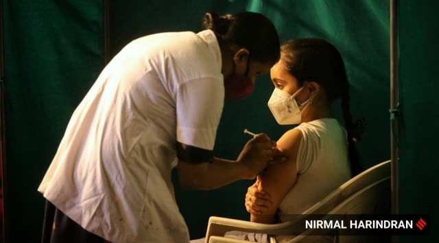 A health worker administers a Covid-19 vaccine at Tagore Hall in Ahmedabad on Friday. 
(Express photo by Nirmal Harindran)