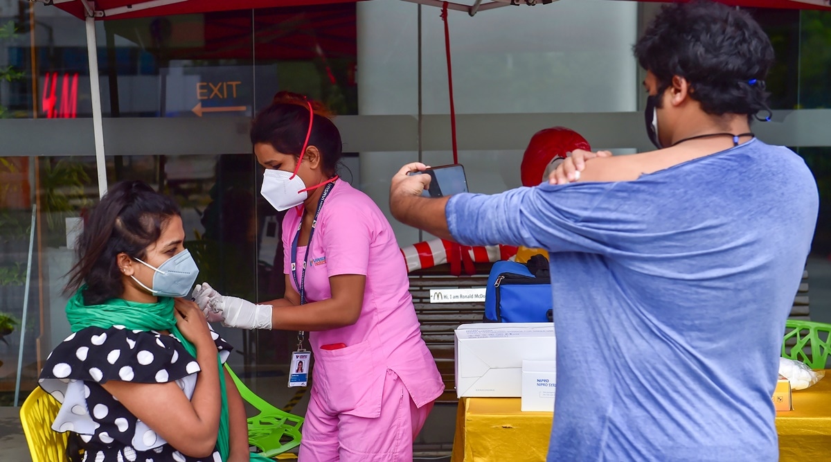 A health worker administers a dose of Covid-19 vaccine to a woman at a drive-in vaccination centre in Bengaluru. (Photo: PTI)