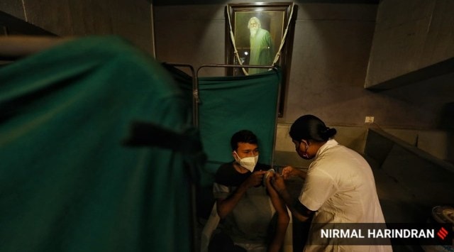 Health workers administering Covid-19 vaccine at Tagore Hall, Ahmedabad on Friday. 
(Express photo by Nirmal Harindran)
