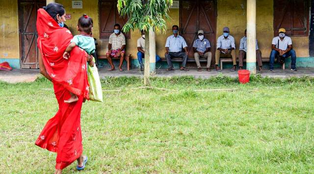 A woman arrives with her child to join the queue at a vaccination centre in Guwahati Tuesday. (PTI)