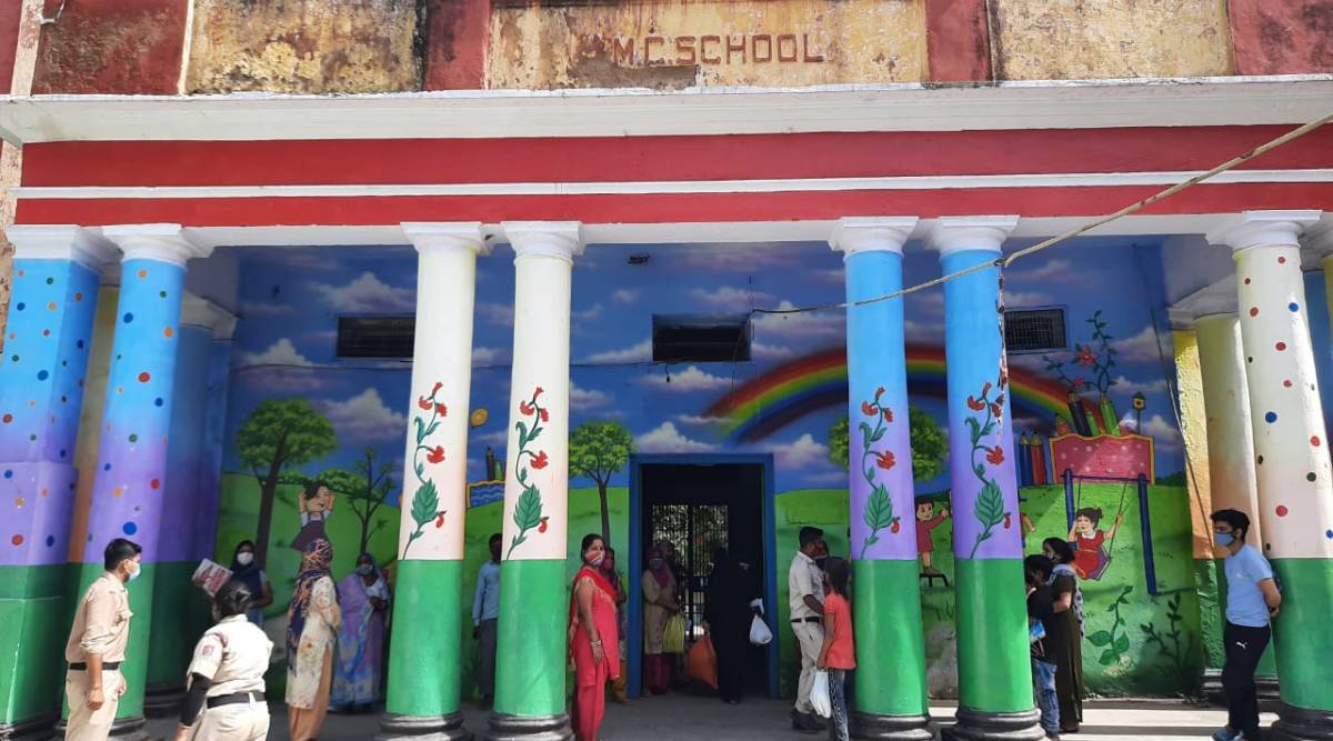 People queue up at an MCD school to collect their ration. (Express Photo: Ashna Butani)