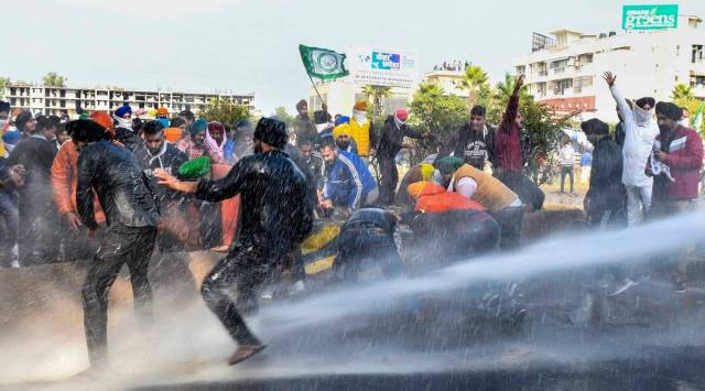 Police personnel use water cannons on farmers to stop them from crossing the Punjab-Haryana border during 'Delhi Chalo' protest march against the new farm laws, near Ambala. (File Photo: PTI)
