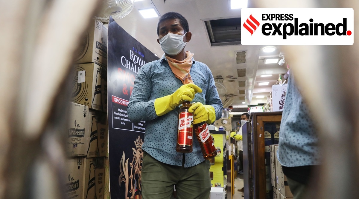 A salesman wears a mask and gloves while selling liquor amid the Covid-19 pandemic. (Express Photo: Partha Paul, File)  