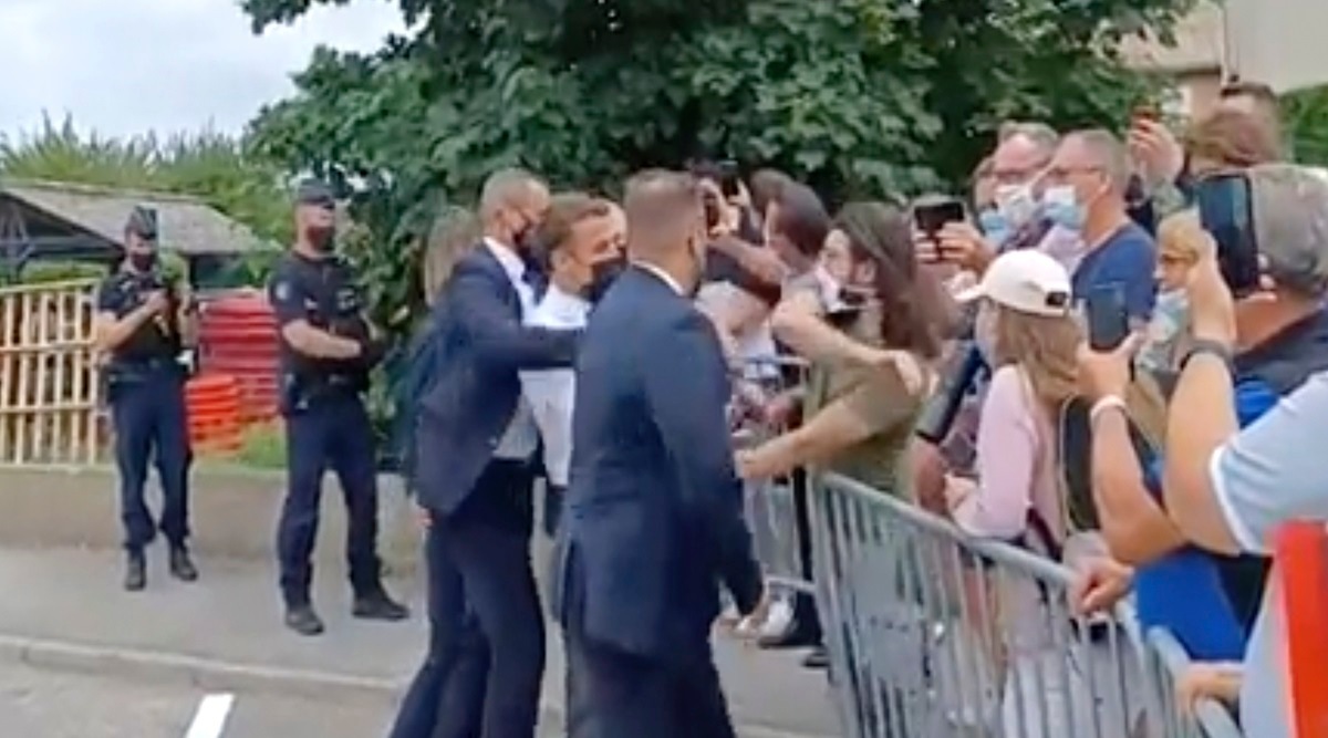 France's President Emmanuel Macron, centre, is slapped by a man, in green T-shirt, during a visit to Tain-l’Hermitage, in France, Tuesday, June 8, 2021. (BFM TV via AP)
