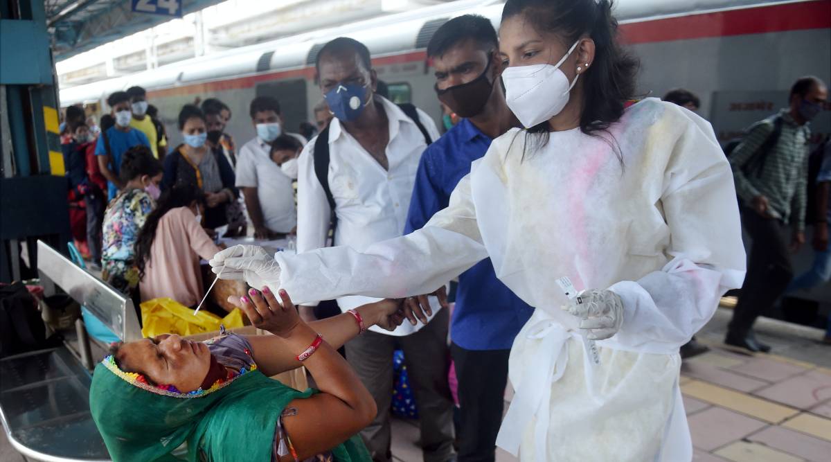 A BMC health worker collects swab sample of a passenger for COVID-19 test, at Dadar railway station in Mumbai, Monday, June 14, 2021. (PTI Photo)