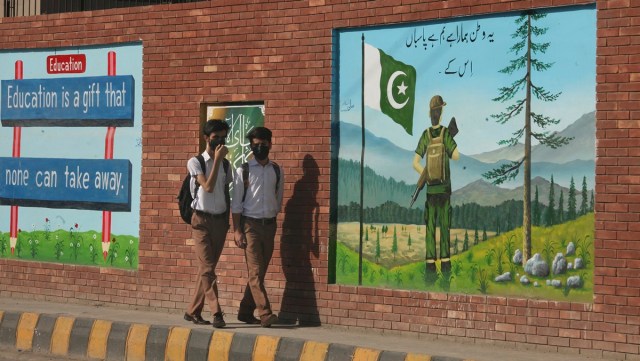 Students wearing face masks to help prevent the spread of the coronavirus while going to school, in Peshawar, Pakistan, Tuesday, June 1, 2021. (AP Photo/Muhammad Sajjad)