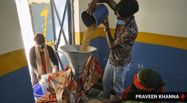 People collect free ration provided by the Delhi government at a government school. (Express Photo: Praveen Khanna, File)
