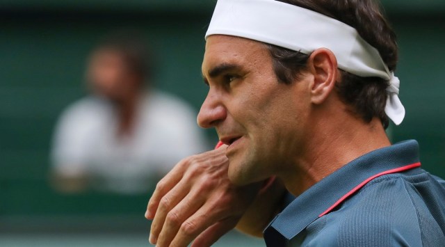 Switzerland's Roger Federer wipes his face during his ATP Tour Singles, Men, Round of 16 tennis match against Canada's Felix Auger-Aliassime in Halle, Germany, Wednesday, June 16, 2021. (Friso Gentsch/dpa via AP)