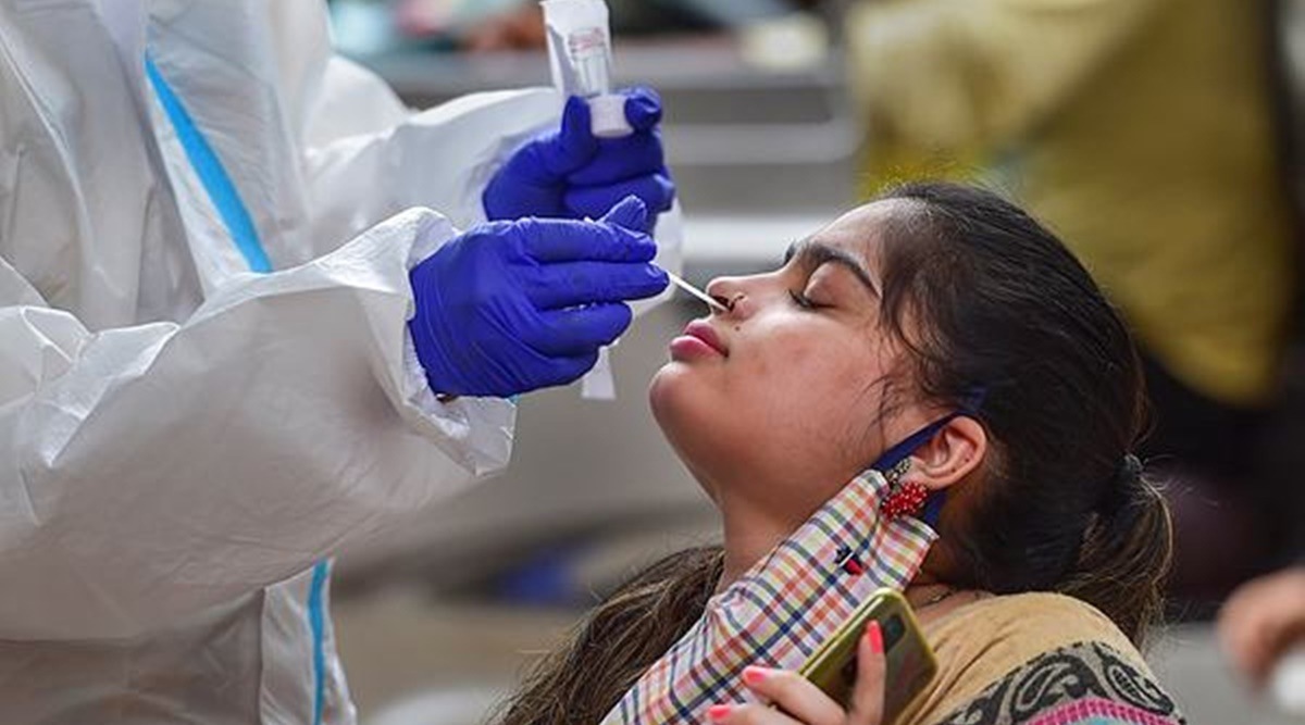A health worker collects swab sample of a woman in Bengaluru on Monday. (PTI photo)