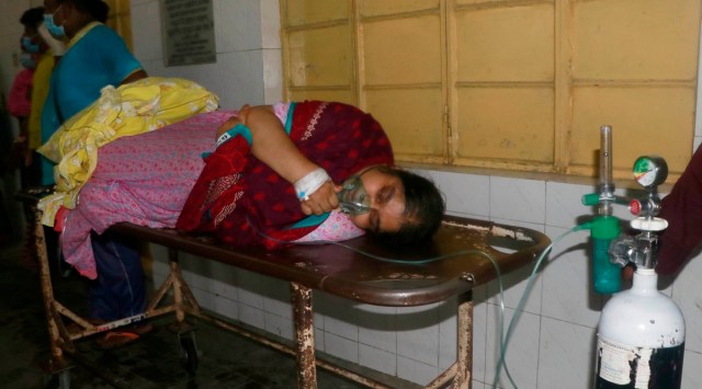 A patient receives oxygen lying on a stretcher at the Medical College Hospital in Rajshahi, Bangladesh (AP)