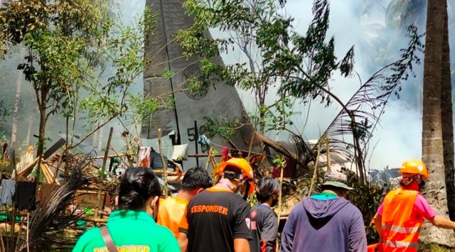 In this photo released by the Joint Task Force - Sulu, rescuers search for bodies from the site where a Philippine military C-130 plane crashed in Patikul town, Jolo province, southern Philippines on Sunday (AP)
