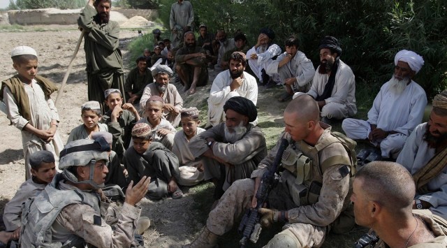 This July 2, 2009, photo shows Josh Habib, far left, a 53-year-old translator for the US Marines, speaking with Afghan villagers and two Marines in the Nawa district of Afghanistan's Helmand province. (AP)