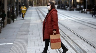 A woman crosses a normally busy street in Sydney. (AP Photo)