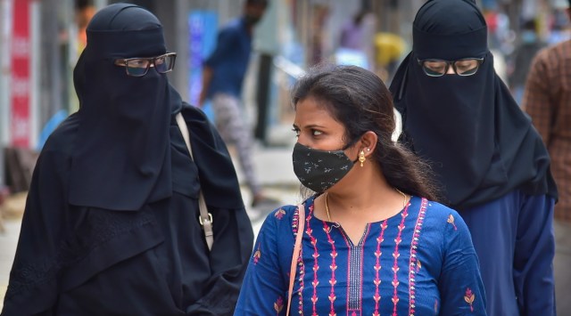 People wearing face mask as a precaution against the coronavirus walk along a commercial street where renovation work is underway as part of Smart City Project, in Bengaluru. (Photo: PTI)