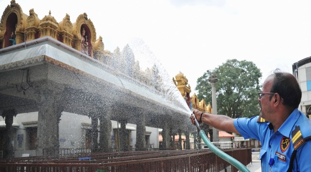 Bengaluru: A worker pours water at a temple after authorities allowed temples to reopen during COVID-induced lockdown in Bengaluru, Sunday, July 4, 2021 (PTI Photo)