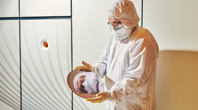 Lead equipment engineer Robert Young holds a silicon wafer from a chip-manufacturing machine at the IBM research facility in Albany, N.Y., June 30, 2021. (Bryan Derballa/The New York Times)