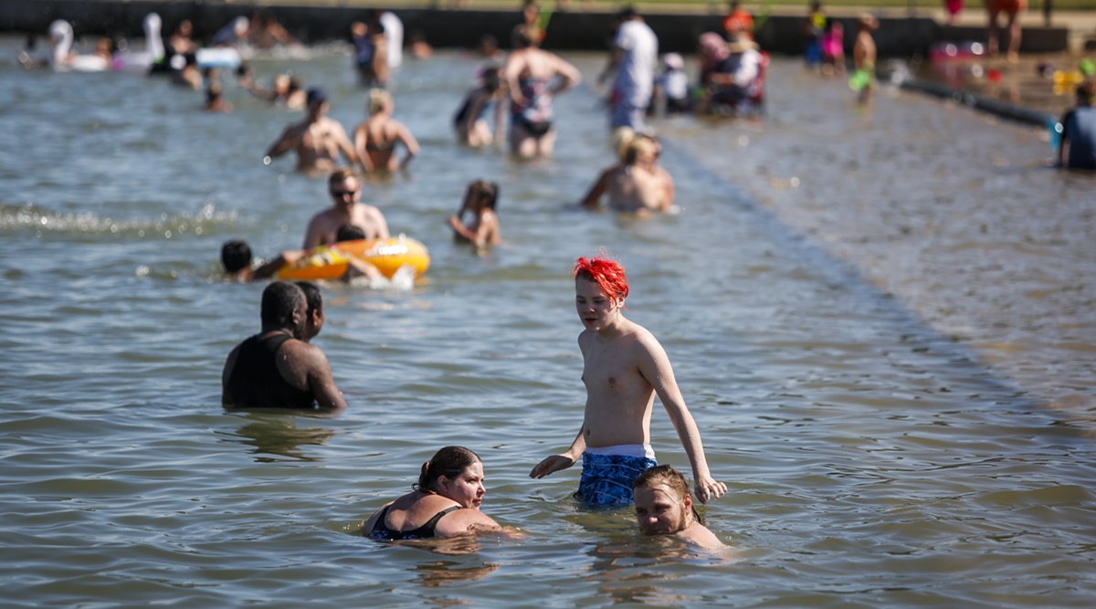 People beat the heat at a beach in Chestermere. Environment Canada warns the torrid heat wave that has settled over much of Western Canada won't lift for days. (Photo: AP)