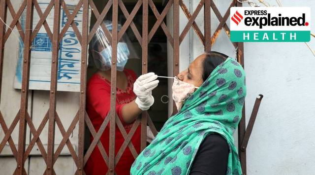 A health worker collects samples for Covid-19 testing at an urban primary health centre in Kolkata. (Express Photo: Partha Paul/File)