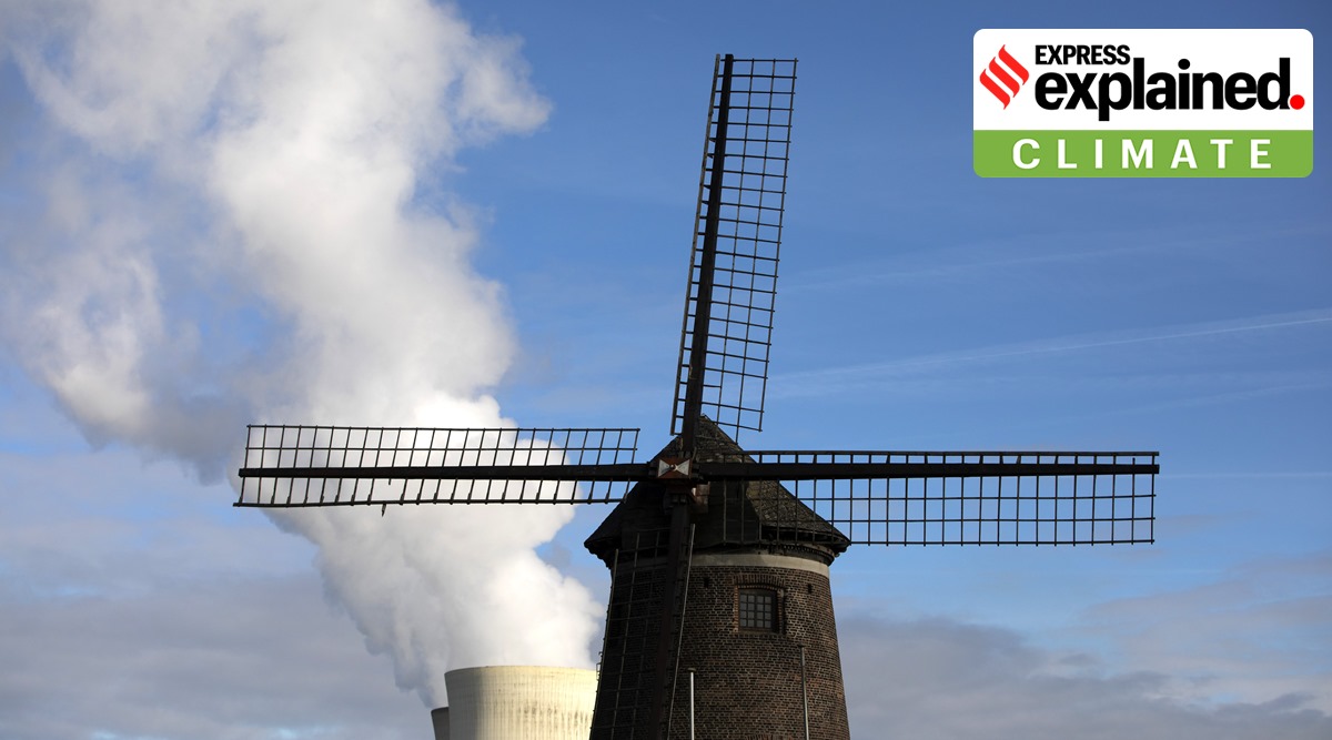 Steam rises from a nuclear power station behind an old windmill on the River Scheldt in Doel, Belgium. (AP Photo/Virginia Mayo, File)