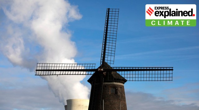 Steam rises from a nuclear power station behind an old windmill on the River Scheldt in Doel, Belgium. (AP Photo/Virginia Mayo, File)