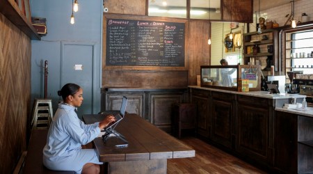 Kia Roberts, an entrepreneur, works from Corner Grind Coffee Kitchen, a coffee shop in New York owned by her husband, July 12, 2021. As the office world adjusts to a new normal and workers grow tired of their homes, WeWork and its competitors reap the benefits. (The New York Times)