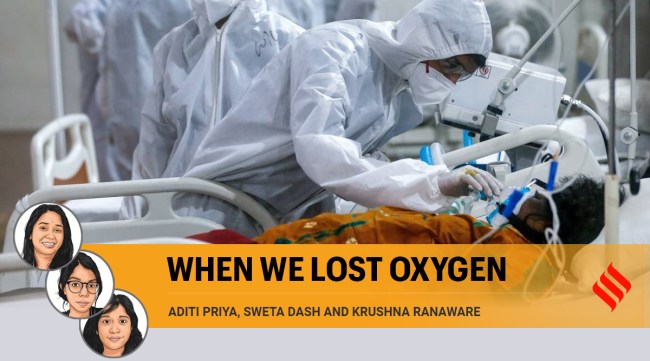 A health worker tries to adjust the oxygen mask of a COVID-19 patient at the BKC field hospital in Mumbai. (Photo: AP/File)