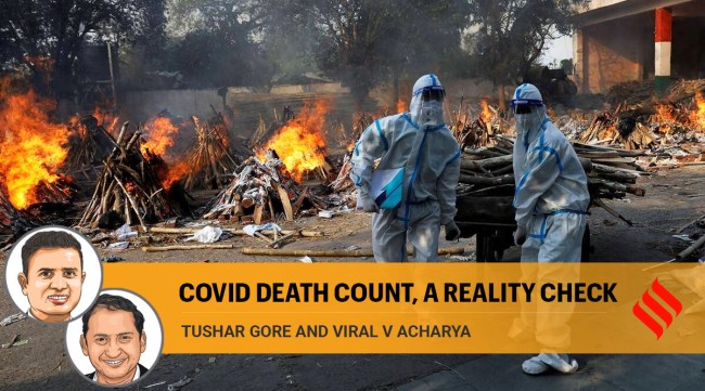 Health workers wearing personal protective equipment carry wood to prepare a funeral pyre for a Covid-19 victim during a mass cremation at a crematorium in New Delhi. (Reuters Photo)
