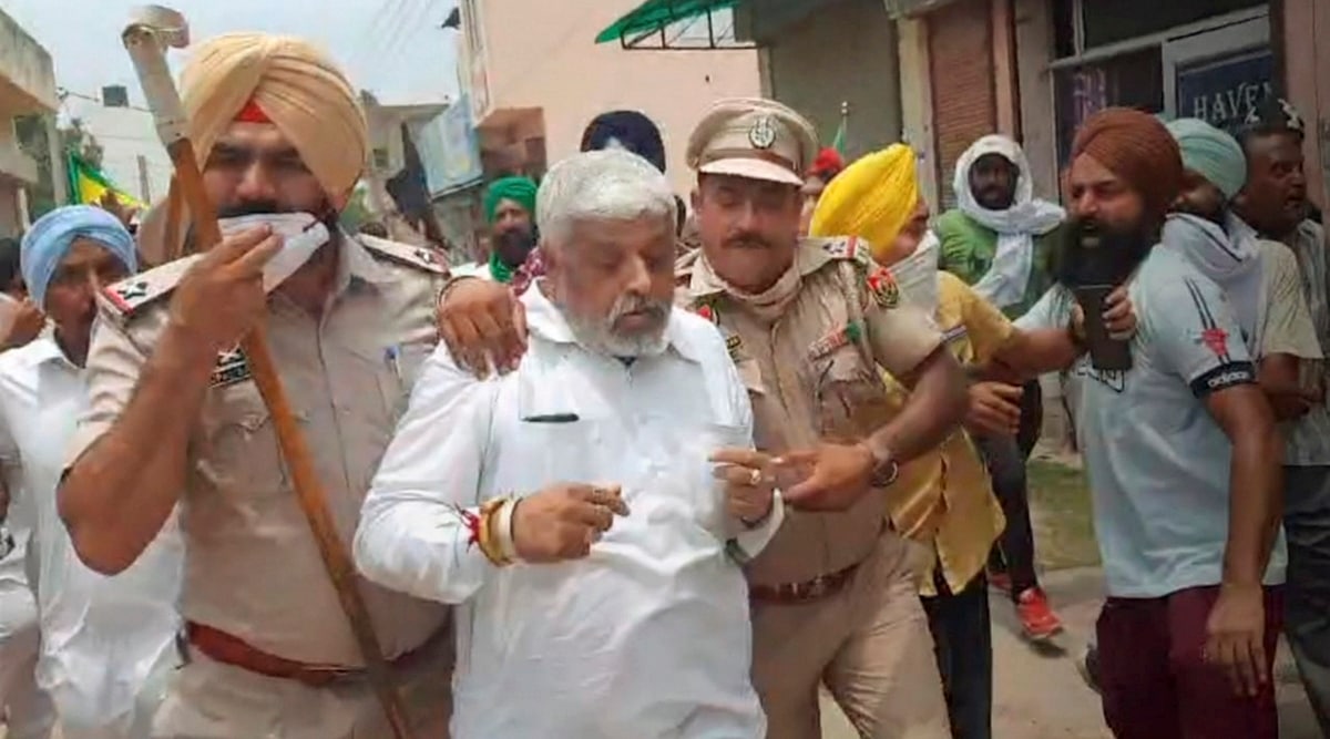 Police personnel protect a BJP leader from the farmers attacking him during their protest aganist three farm laws, at Rajpura in Patiala, Sunday, July 11, 2021. (PTI) 